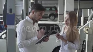 漂亮的女经理告诉英俊的客户如何填写机修合同，并在汽车服务中微笑