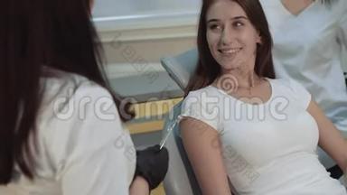 快乐的女孩坐在牙医椅子上咨询，微笑。 4K