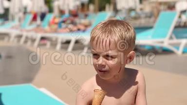 一个小孩子在暑假在游泳池附近吃巧克力冰淇淋。