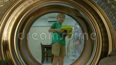 从洗衣机里看到一个小男孩把脏衣服放进洗衣机里