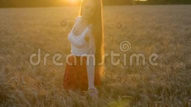 美丽的长发年轻女子在麦穗中旋转。 夕阳西下。 <strong>启示</strong>