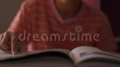 小女孩阅读和<strong>翻书</strong>页。 女学生在阅读时手指沿着页面移动。