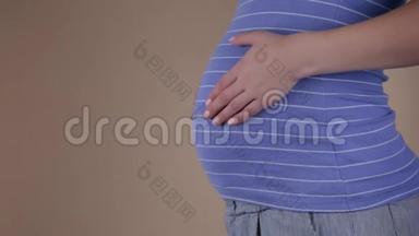 一个穿着<strong>睡衣</strong>的年轻<strong>孕妇</strong>的真实特写镜头正在抚摸她早上刚醒来的腹部。