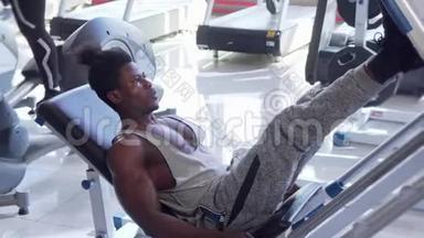 运动青年非洲男子在健身房锻炼腿部按压机
