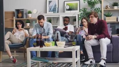 男人和女人使用智能手机，然后一起在家里看电视新闻