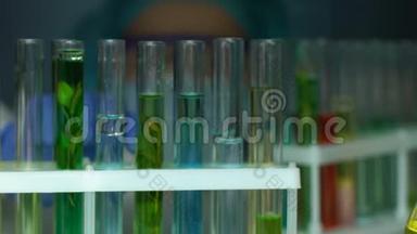 实验室助理从试管架取绿色液体样品，美容