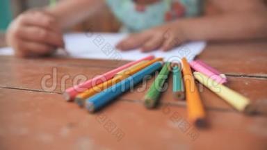 小六岁的女孩用彩色铅笔画画.. 近距离观看铅笔。