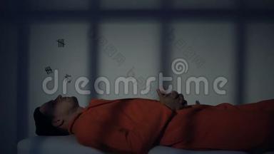 白种人囚犯躺在木板床上思考<strong>终身</strong>监禁