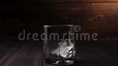 豪华<strong>威士忌</strong>。 冰落在一杯<strong>威士忌</strong>中，位于木制桌子上，背景是木制的。 不倒翁<strong>威士忌</strong>。 波旁酒。