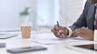 非洲商人在办公室处理财务文件的特写镜头