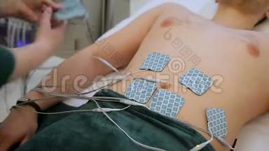 静电按摩程序。 女医生将电极贴在病人腹部