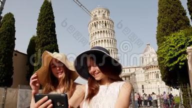 意大利<strong>比萨</strong>。 两个年轻微笑的女人在巴拿马站在<strong>比萨斜塔</strong>的背景上，带着一个