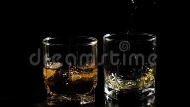 豪华<strong>威士忌</strong>。 手把金色的<strong>威士忌</strong>从一个方形的瓶子里倒入一个玻璃杯，放在靠近玻璃杯的黑桌上，里面有<strong>威士忌</strong>和冰。