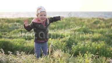 一个小女孩走在海边。 她跳起来笑了