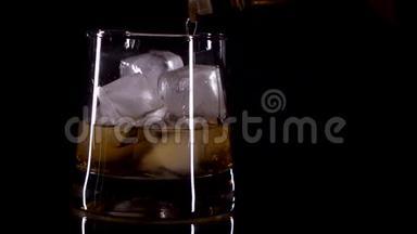 威士忌被<strong>倒入</strong>一个带有黑色背景的冰的玻璃<strong>杯中</strong>
