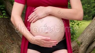 心脏形状的怀孕。 未来<strong>妈妈</strong>和父母的手拥<strong>抱</strong>，拥<strong>抱</strong>和抚摸肚子，她正在肚子上做心脏符号。