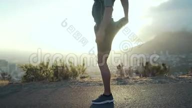 男跑运动员在旭日前伸展腿