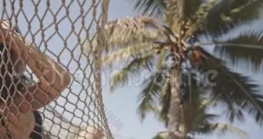 亚洲女孩在吊<strong>床</strong>上的热带海滩旁边的棕榈树看着什么。 异国情调，放松，生活方式，<strong>广告</strong>