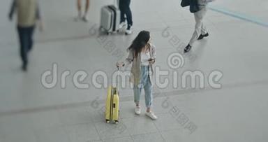 美丽的梦想女子站在机场旁。 手里拿着手机。 用12位的佳能相机拍摄