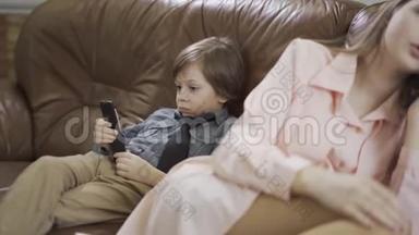 小男孩坐在沙发上在沙发上，<strong>小妹</strong>妹坐在旁边，用手机说话