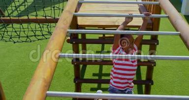 非裔美国小学生在学校操场上横梯玩耍的高视角