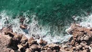 大浪的高空俯视图.. 岩石海岸的无人机射击。 具有极端波浪的海洋海岸线。 波浪撞击岩石。 波浪碰撞