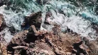 无人机飞过大洋岩石。 海浪的空中景色。 海浪冲击海岸。 海浪飞溅，制造泡沫。 cl