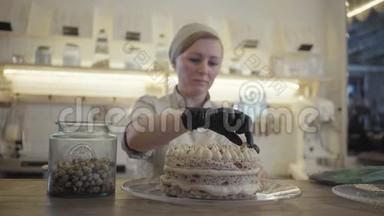 穿制服的糖果工把刚做好的甜面菜或球放在餐厅背景上装饰蛋糕
