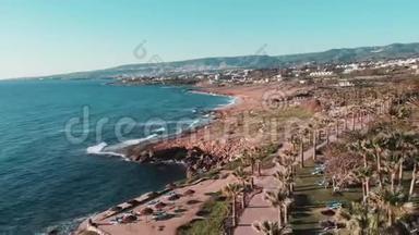 塞浦路斯珊瑚湾<strong>岩石</strong>海岸的顶部景观，有棕榈树、酒店和度假村。 强烈的<strong>海浪</strong>冲击着<strong>岩石</strong>海岸
