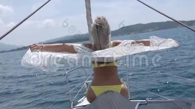 女孩躺在游艇的鼻子上。 风<strong>吹拂</strong>着金色的长发
