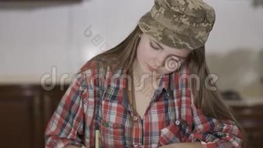 身着格子衬衫，头戴军帽的漂亮少女的肖像，坐在家里写着一封信