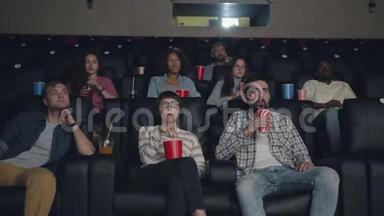 一群朋友在电影院里看电影，吃喝玩乐，坐在一起