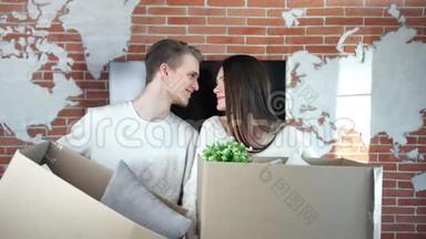 一对幸福的年轻夫妇在移动时拿着一个装有物品的拆<strong>包箱</strong>