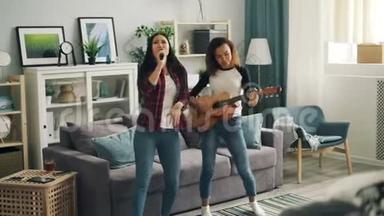 穿着休闲服装的非裔美国人<strong>和</strong>亚裔年轻妇女正在电视上弹吉他、<strong>跳舞和唱歌</strong>