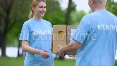 微笑青年妇女向高级志愿者捐赠捐款箱