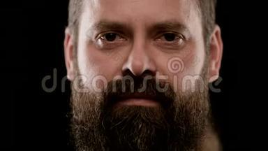 一个长着棕色眼睛胡子的成年男子的严厉面孔的大特写