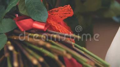 剪裁的大<strong>红玫瑰</strong>花束视频。 把注意力集中在用漂亮的结绑起来的红色丝带上。