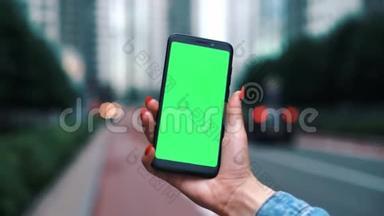 乌克兰基辅-2019年6月5日：美丽的女孩手里<strong>拿</strong>着智能<strong>手机</strong>，手里<strong>拿</strong>着绿色屏幕，手里<strong>拿</strong>着绿色屏幕。