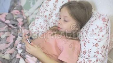 一个生病的小女孩和她的母亲躺在床上，看着智能手机屏幕上的卡通片、儿童和数字