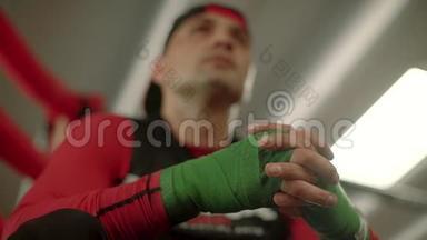 拳击手，拳击手在准备战斗的戒指上戴着手包。 一看