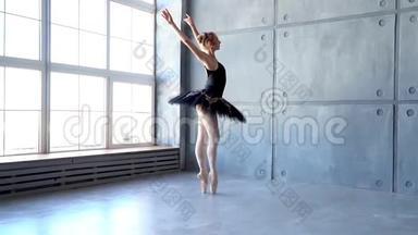 芭蕾舞学校的女舞蹈演员学会跳舞。 穿着黑色舞服训练的小芭蕾舞女。 孩子们`芭蕾