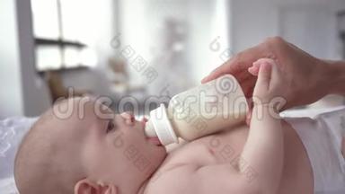母亲手里拿着一瓶牛奶，婴儿尿布上的<strong>新生儿躺</strong>在换尿布的画像