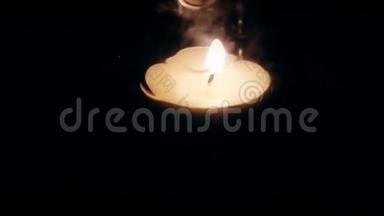 一个蜡烛火焰和玻璃在黑暗的4K视频