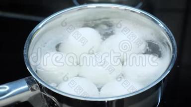 把煮好的鸡蛋放在锅里。 厨师在智能厨房煮鸡蛋。 煮鸡蛋的过程。 健康食品