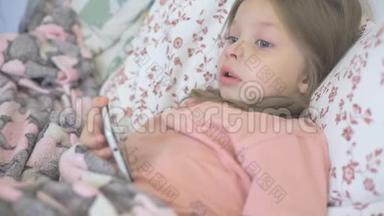 一个生病的小女孩和她的母亲躺在床上，看着智能手机屏幕上的卡通片、儿童和数字