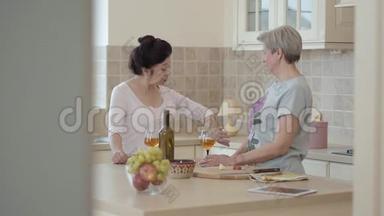 两个成熟的女人站在厨房的现代餐桌旁交流。 有感情地<strong>讲故事</strong>