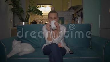 女孩喝咖啡/茶，和她的猫一起看电视。 4K