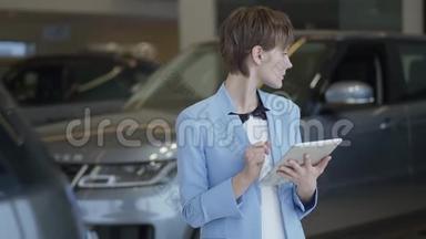 一幅自信的漂亮女人穿着时尚西装，在<strong>车展</strong>上用平板电脑检查汽车的肖像。 女士检查
