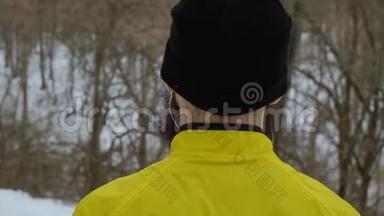 戴耳机的留胡子男子站在冬林后景特写