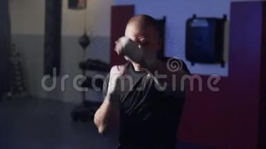 拳击手训练在健身房向<strong>摄像机</strong>投掷拳头，影子在缓慢<strong>运动</strong>中战斗。